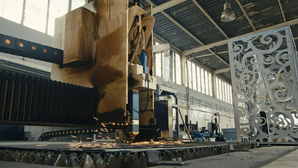 Interior of a metal fabrication shop in Laval with overhead crane, CNC laser and TIG welding stations