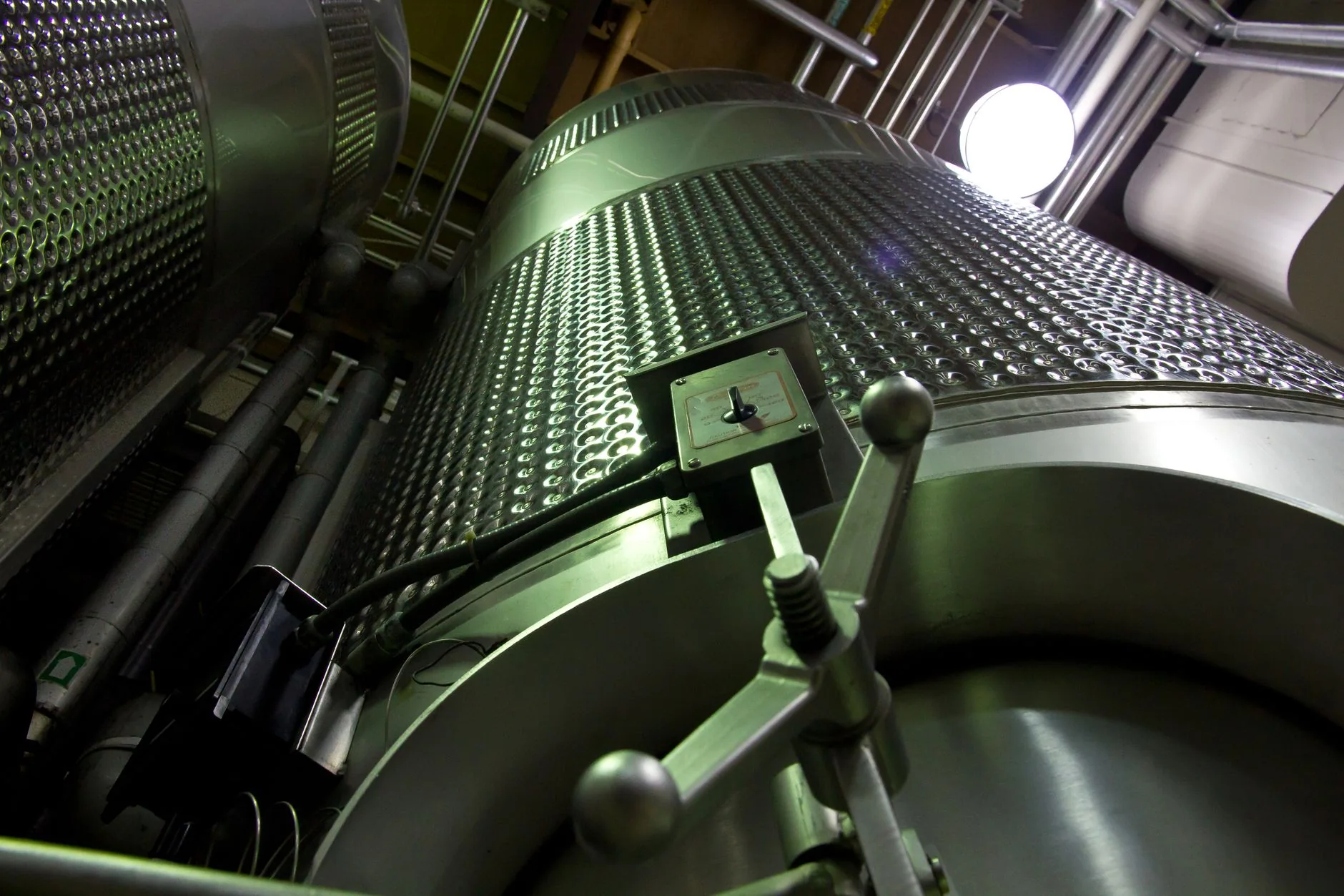 Large industrial stainless steel tanks with dimpled walls and process piping.