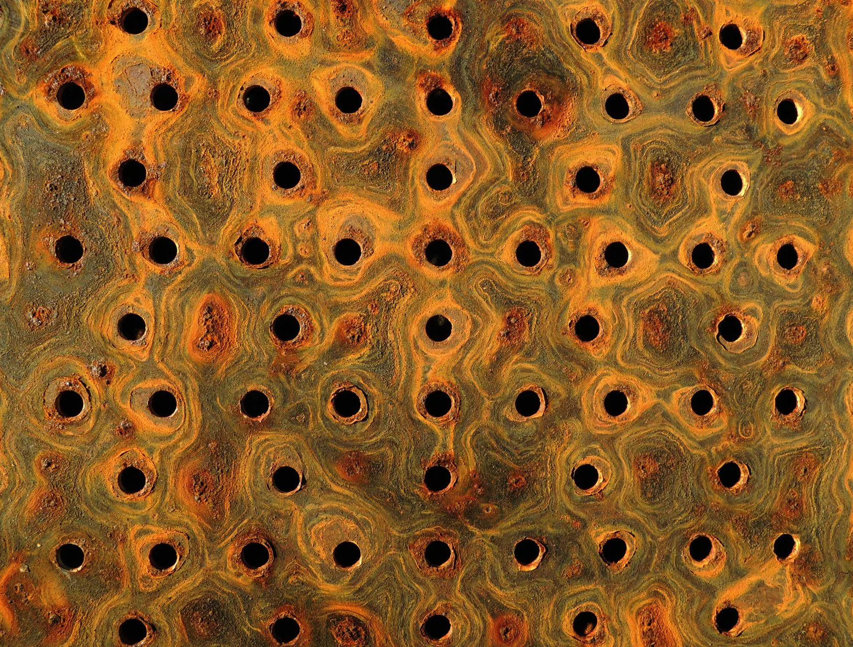 Perforated metal surface showing many areas of localized corrosion.